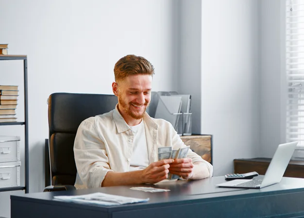 Successful debt collection: person at a desk counting banknotes